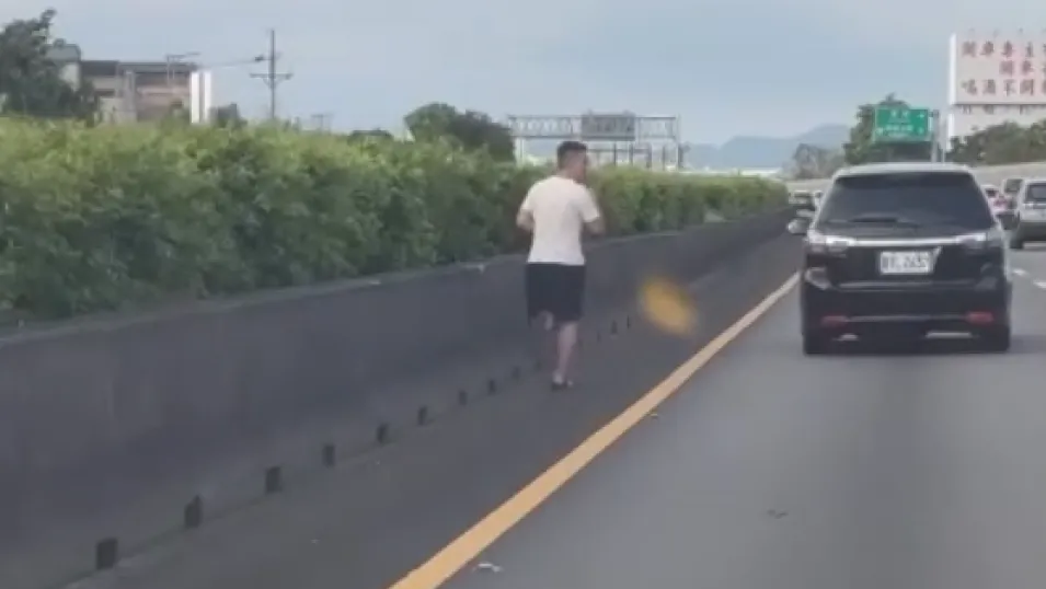 國道1號內側路肩穿拖鞋拿手機跑步! 警方將開罰