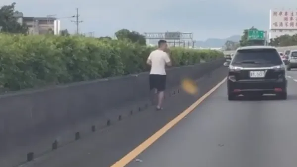 國道1號內側路肩穿拖鞋拿手機跑步！　警方將開罰